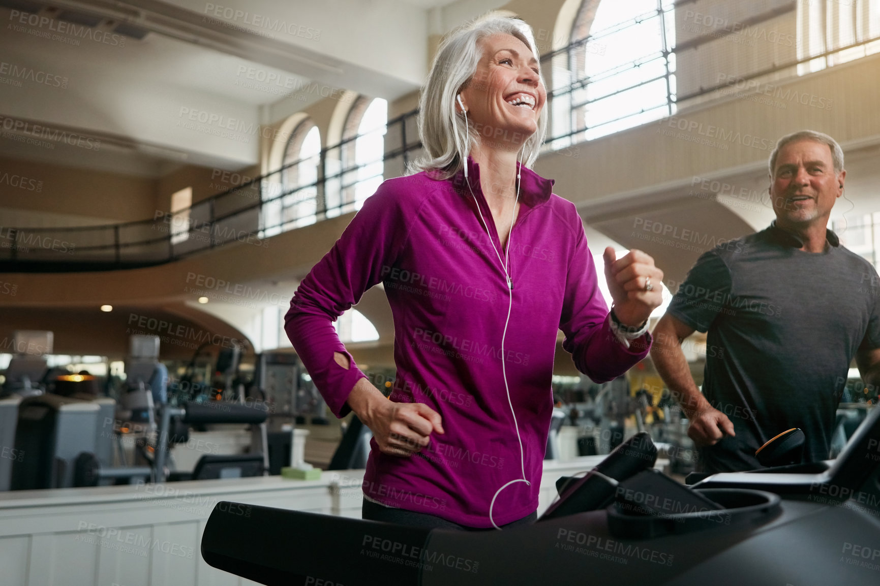 Buy stock photo Shot of a mature woman and man exercising on treadmills at the gym