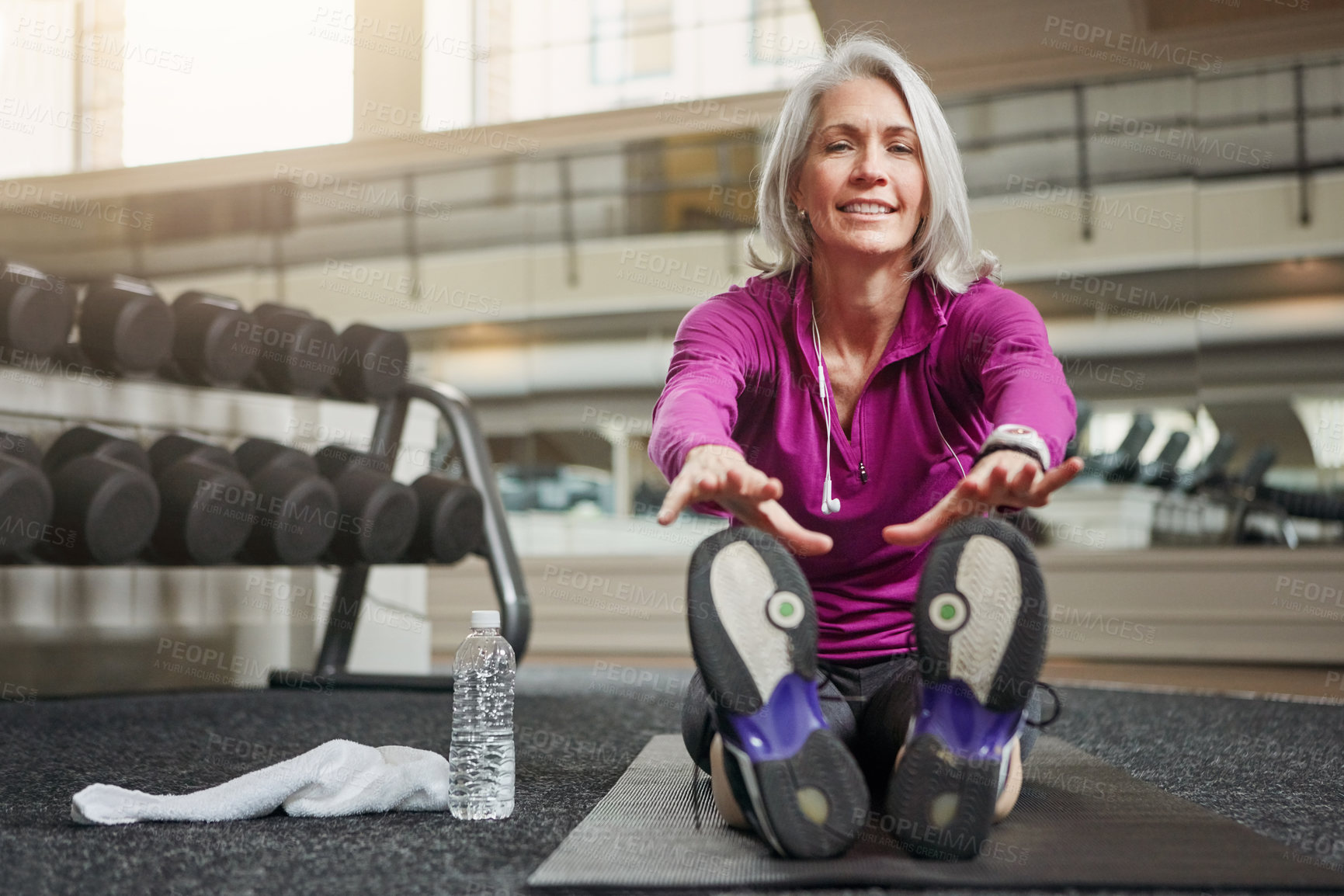 Buy stock photo Mature woman, stretching legs and gym on floor, warmup routine or smile in portrait for workout. Person, muscle and start training for wellness with development, ready or exercise mat at fitness club