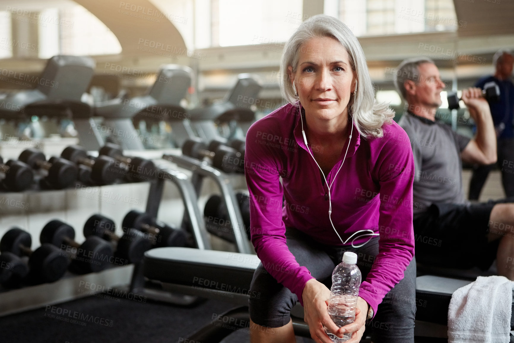 Buy stock photo Fitness, portrait and senior woman in gym with water bottle for training, exercise and workout. Sports, retirement and person with liquid, headphones and listening to music for wellness and health