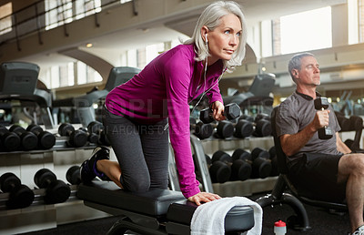 Buy stock photo Shot of a senior married couple working out together at the gym