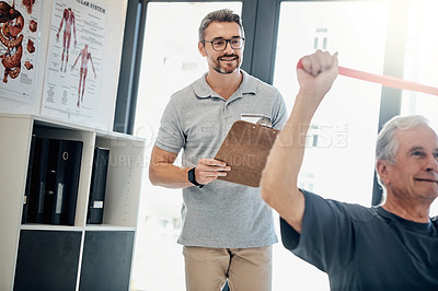 Buy stock photo Shot of a friendly physiotherapy supervising his mature patient while he works out in the rehabilitation center