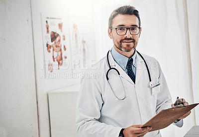Buy stock photo Portrait of a happy doctor holding a clipboard while standing in his consultation room