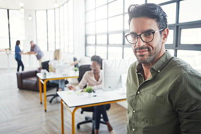 Buy stock photo shot of a male designer in a office with his colleagues in the background