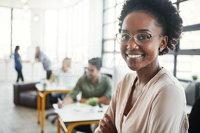 Buy stock photo Portrait of a young designer standing in an office with her colleagues in the background