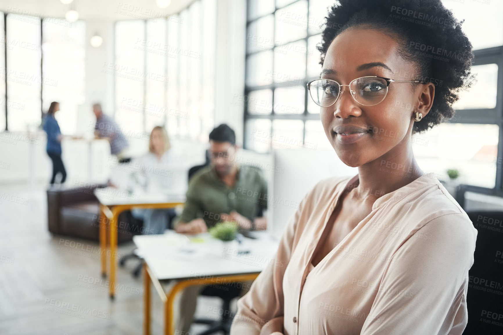 Buy stock photo Portrait of a young designer standing in an office with her colleagues in the background