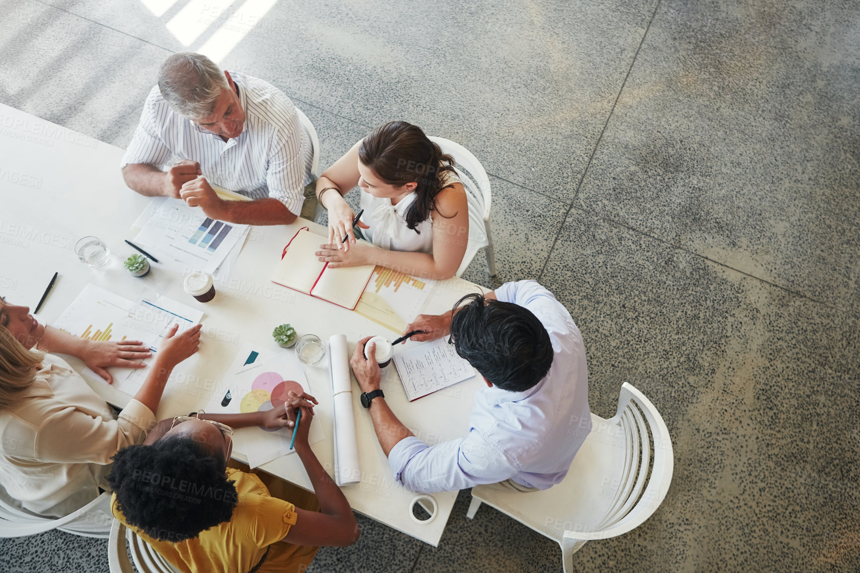 Buy stock photo High angle shot of a team of businesspeople having a meeting around a table in their office