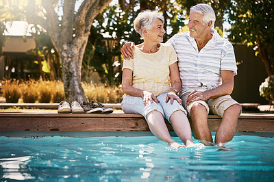 Buy stock photo Senior couple, hug and swimming pool for holiday in relax for love or quality bonding time together on summer vacation. Happy elderly man holding woman relaxing with feet in water by the poolside