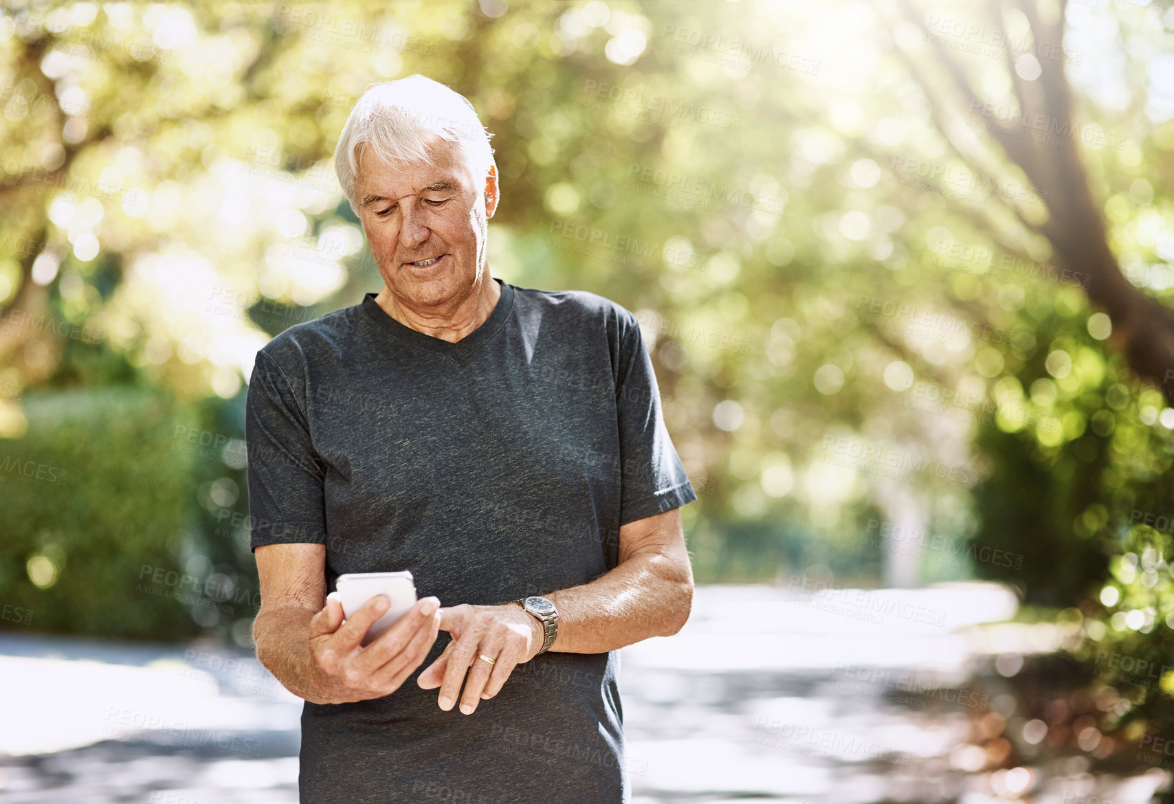 Buy stock photo Shot of a senior man texting on a cellphone while out for a run