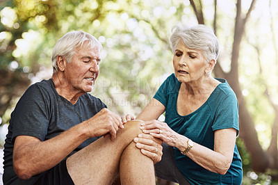 Buy stock photo Shot of a senior man suffering from an injury while out for a run with his wife
