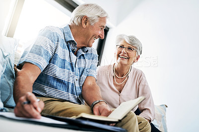 Buy stock photo Shot of a senior couple going through their paperwork together at home