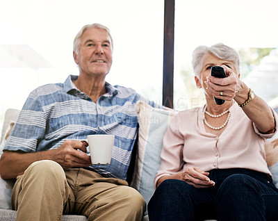 Buy stock photo Shot of a senior couple relaxing on the sofa and watching tv together at home