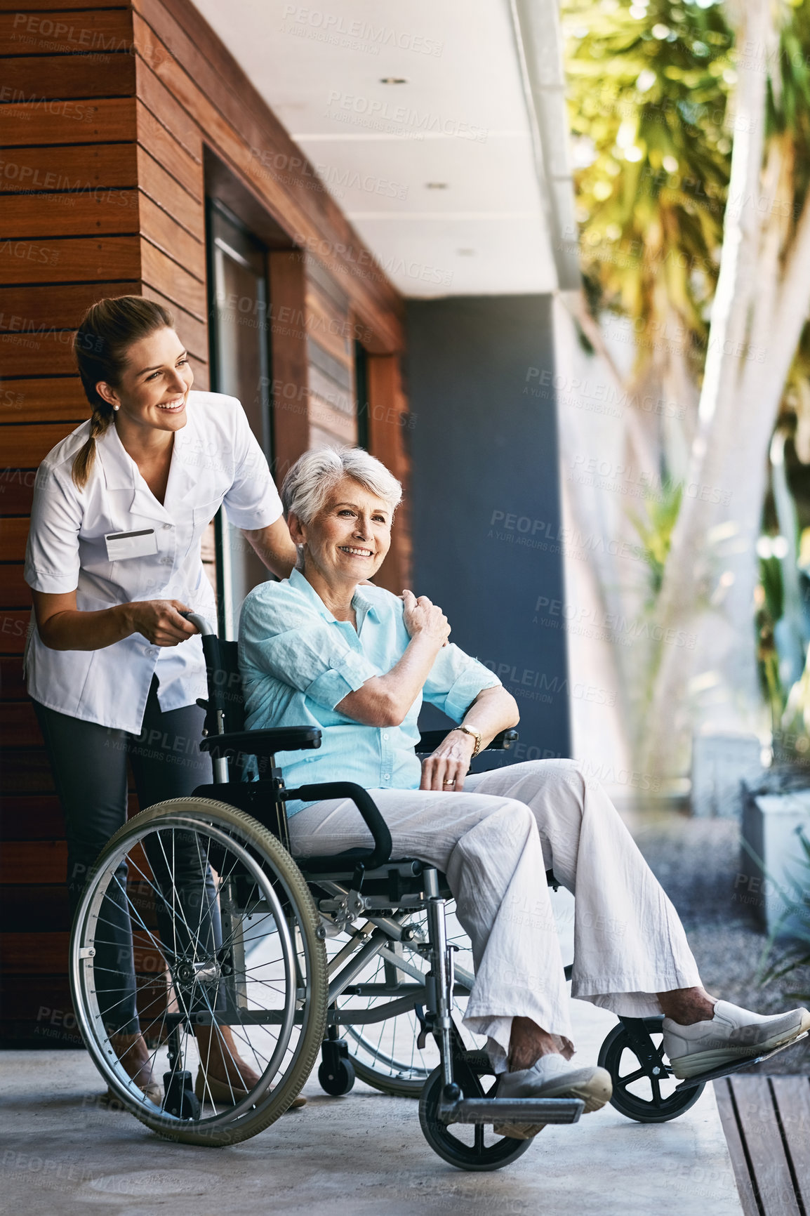 Buy stock photo Shot of a nurse caring for a senior patient in a wheelchair outside a retirement home