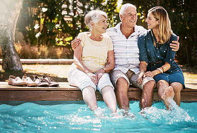Buy stock photo Shot of a happy young woman spending quality time with her elderly parents at the pool