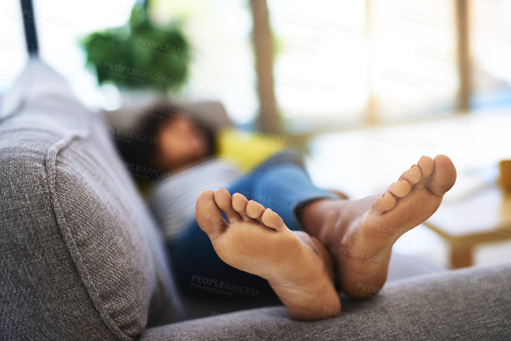 Buy stock photo Shot of an unrecognizable woman relaxing at home on the weekend