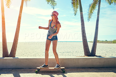 Buy stock photo Shot of a young woman hanging out on the boardwalk with her skateboard