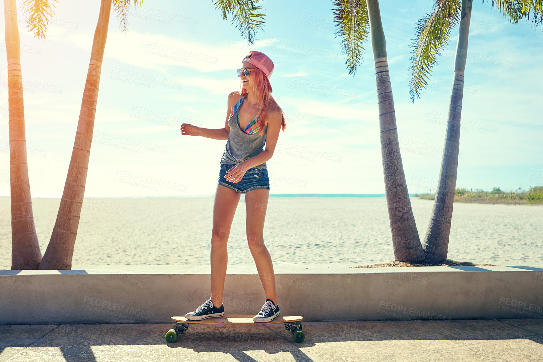 Buy stock photo Shot of a young woman hanging out on the boardwalk with her skateboard