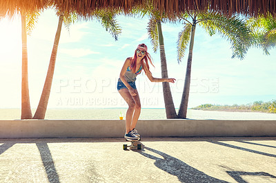 Buy stock photo Shot of a young woman hanging out on the boardwalk with her skateboard