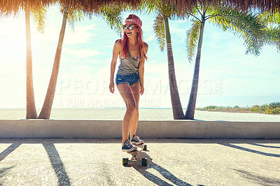 Buy stock photo Shot of a young woman hanging out on the boardwalk with her skateboard