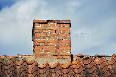 Buy stock photo An orange bricked roof with chimney against the blue sky with copy space on a sunny day. A brick chimney on the roof in the blue cloudy sky background. A closeup of the chimney on the rooftop.