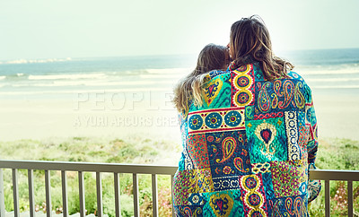 Buy stock photo Shot of an affection young couple wrapped in a blanket on the balcony