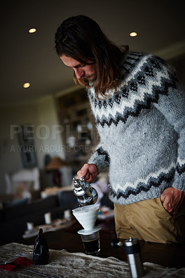 Buy stock photo Shot of a young man preparing coffee in his kitchen