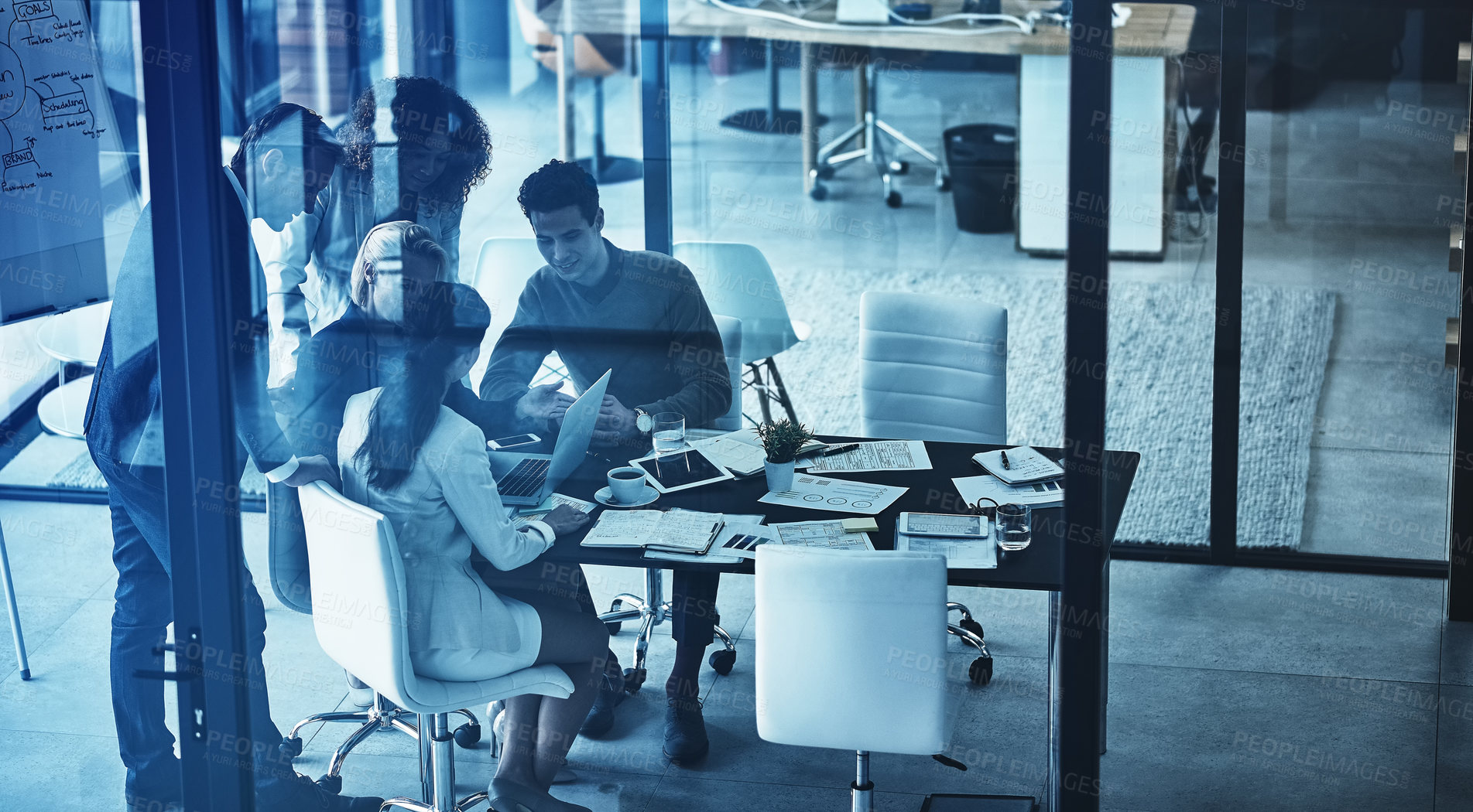 Buy stock photo Shot of a group of corporate businesspeople looking at a laptop together during a meeting in the boardroom