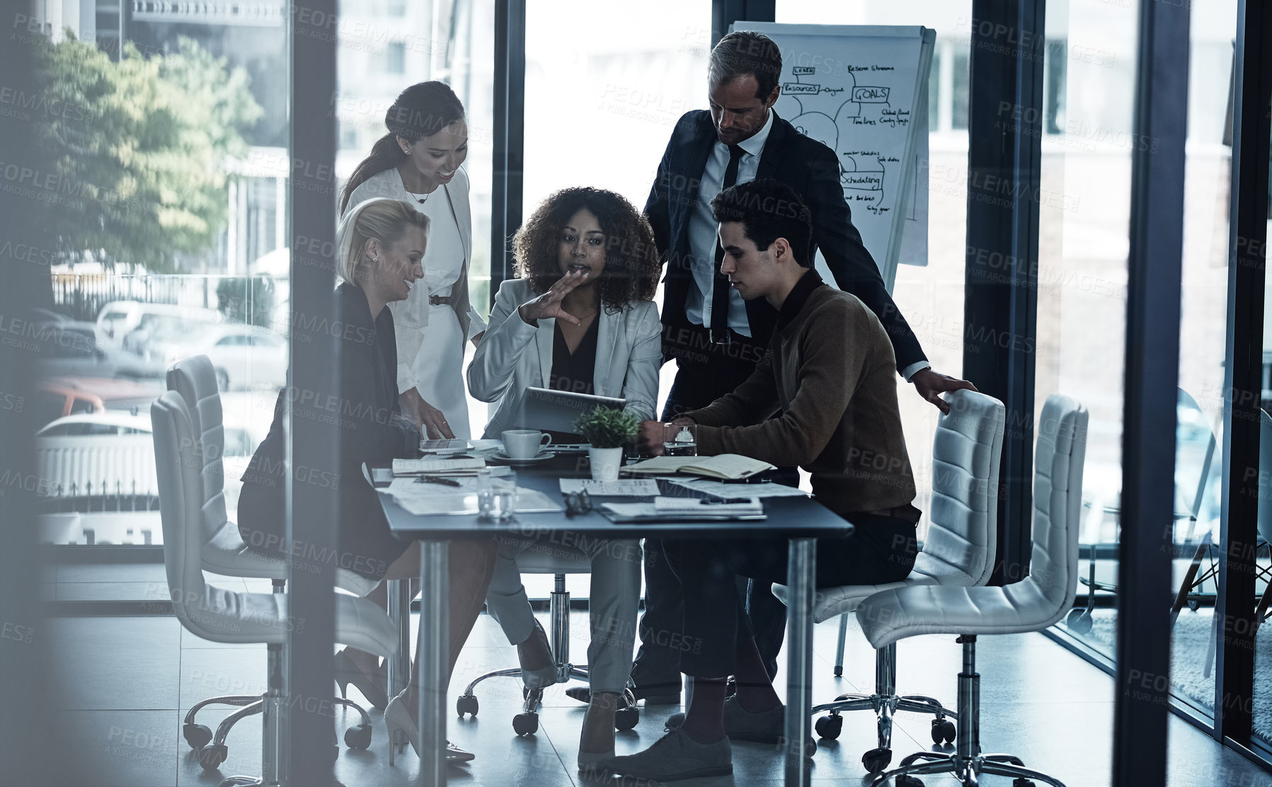 Buy stock photo Shot of a group of corporate businesspeople looking at a tablet together during a meeting in the boardroom