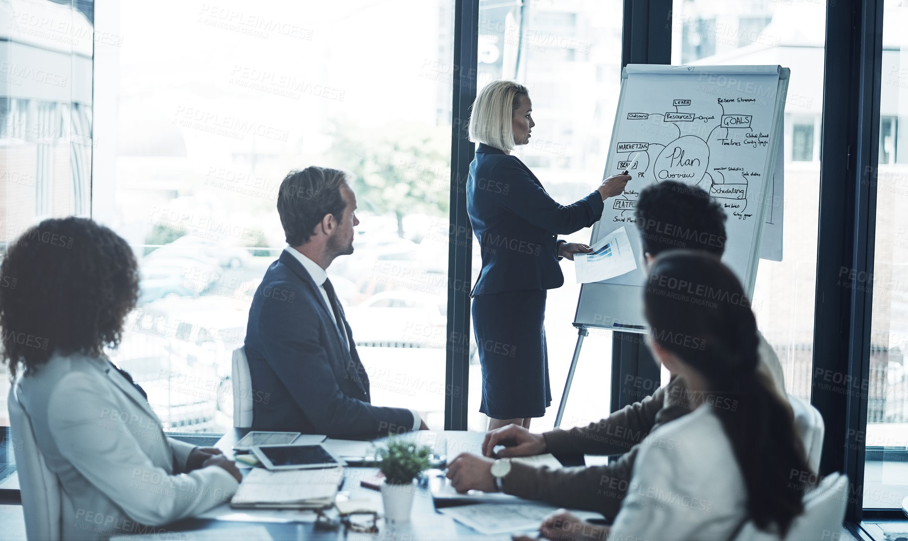 Buy stock photo Shot of a corporate businesswoman giving a presentation to her colleagues in the boardroom