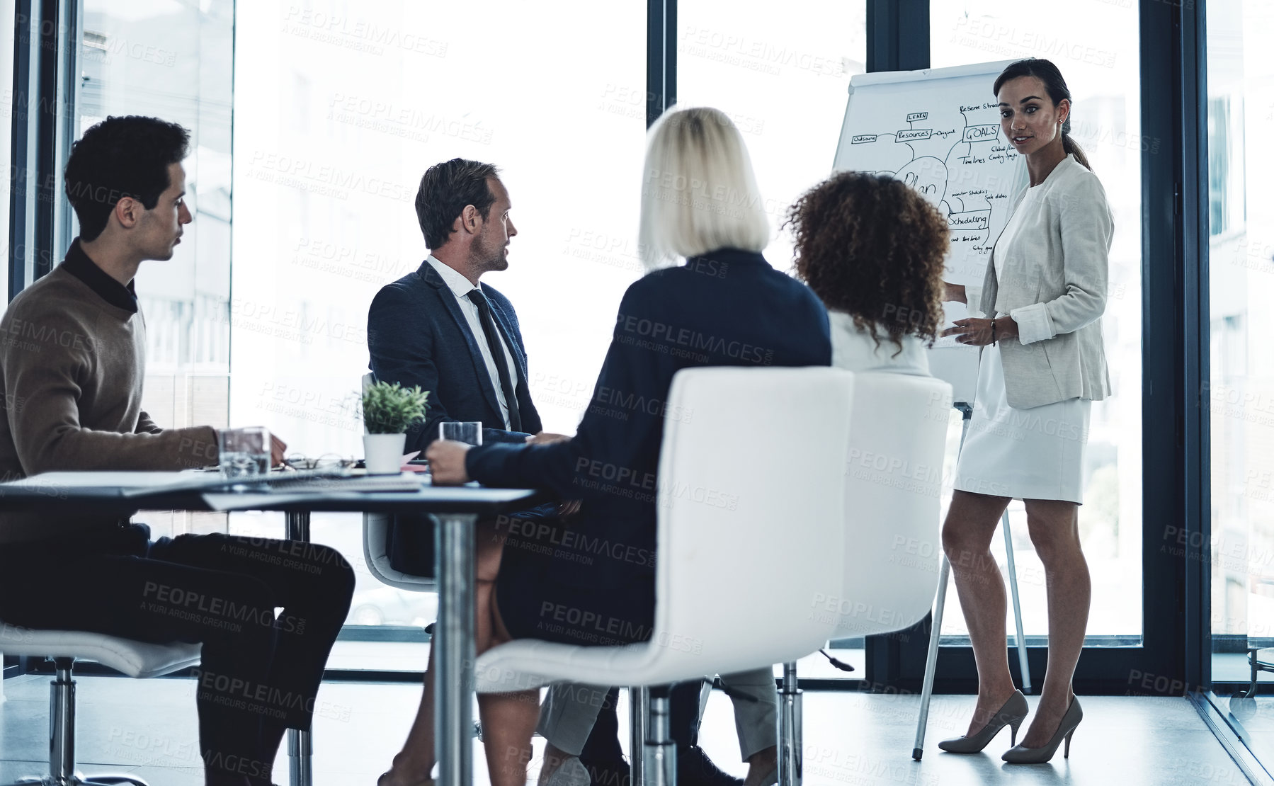 Buy stock photo Shot of a corporate businesswoman giving a presentation to her colleagues in the boardroom