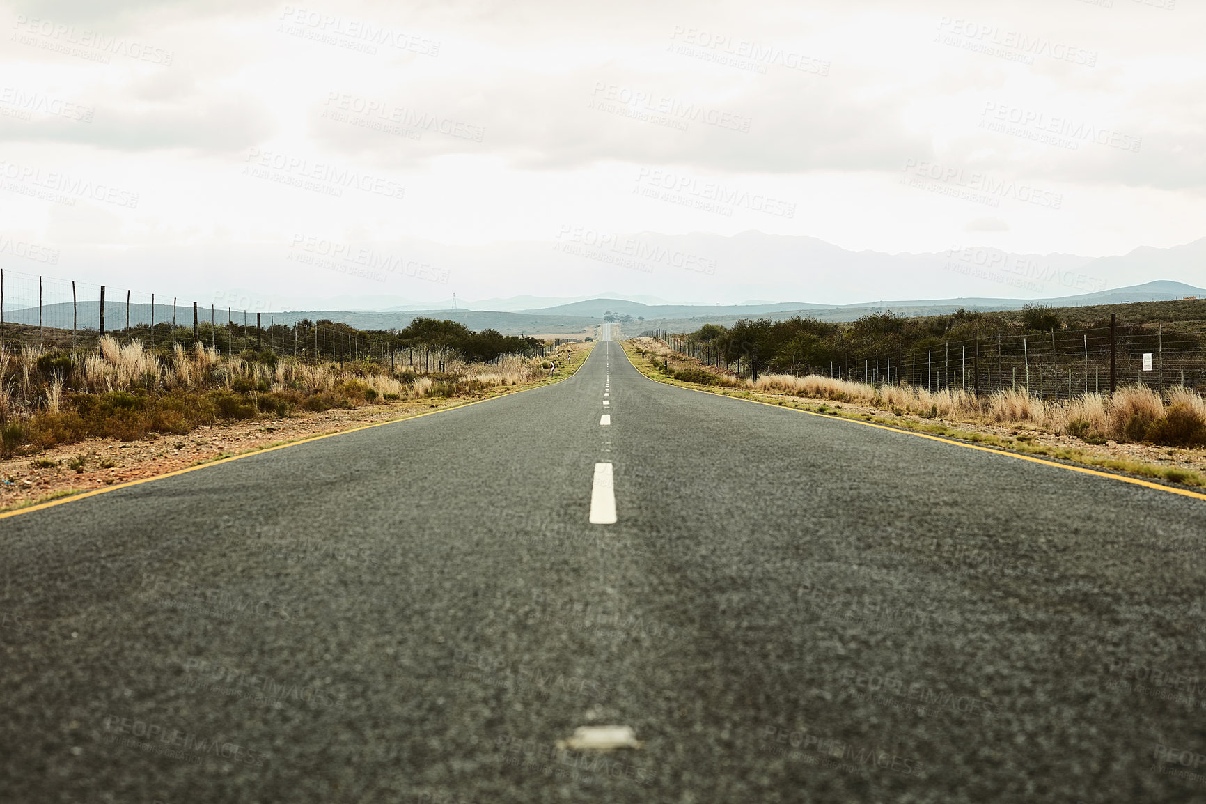 Buy stock photo Shot of a long open road stretching out far away into the distance