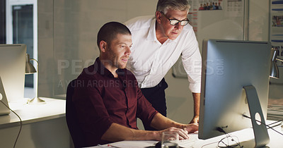 Buy stock photo Cropped shot of two businessmen working together on a computer in their office