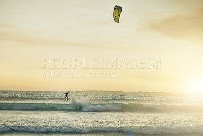Buy stock photo Rearview shot of a young woman kitesurfing at the beach