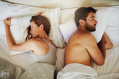 Buy stock photo High angle shot of an arguing couple with their backs turned on each other in bed