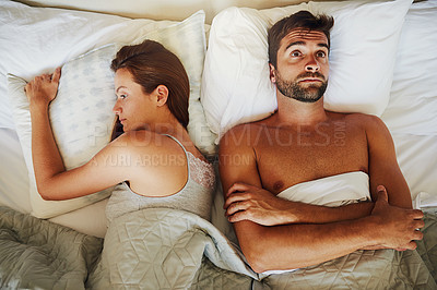 Buy stock photo High angle shot of an arguing couple ignoring each other in bed