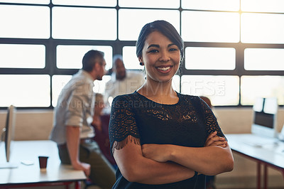 Buy stock photo Shot of a designer standing in an office with her colleagues in the background