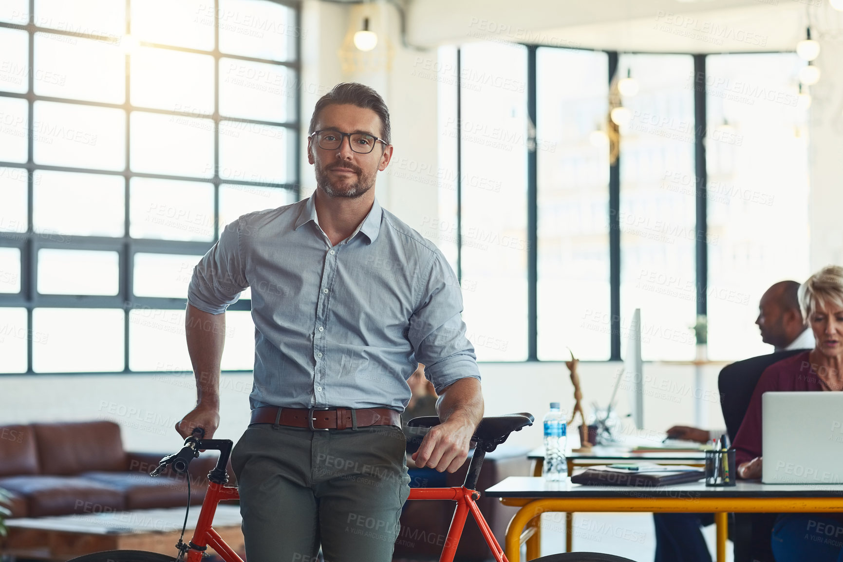 Buy stock photo Portrait of a mature designer standing in an office with his bicycle