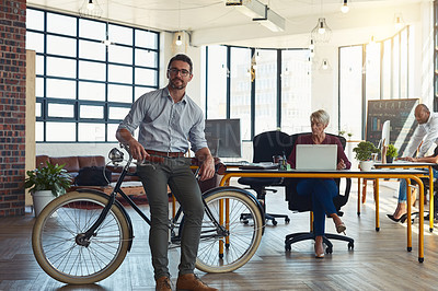 Buy stock photo Portrait of a mature designer standing in an office with his bicycle