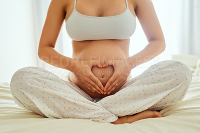 Buy stock photo Woman, pregnant and heart hands on bed for love, future and care for unborn baby. IVF healthcare, expecting mom and holding abdomen at home for wellness, maternity leave and childcare in bedroom