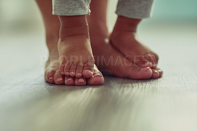 Buy stock photo Feet, walking and toddler with parent, floor and family in house, growth and development of youth. Wood, baby and standing with mother, learning and moving of child with support in home and person