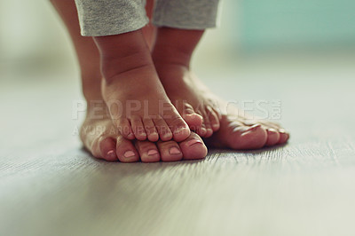 Buy stock photo Shot of an unrecognizable mother's feet and her child's feet at home