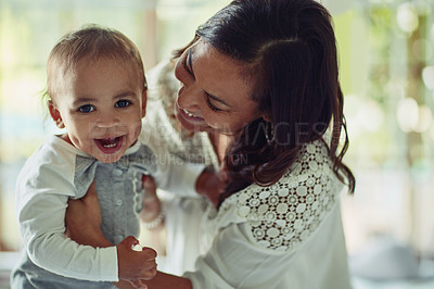 Buy stock photo Shot of a mother and her adorable son laughing together at home