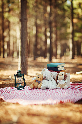 Buy stock photo Shot of teddybears sitting on a picnic blanket in the woods