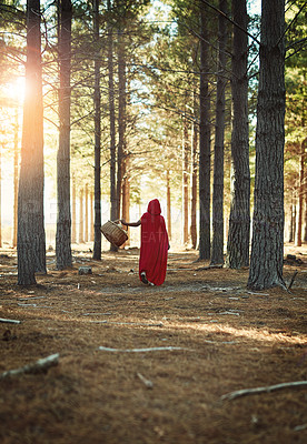 Buy stock photo Rear view shot of a little girl in a red cape walking in the woods with a basket