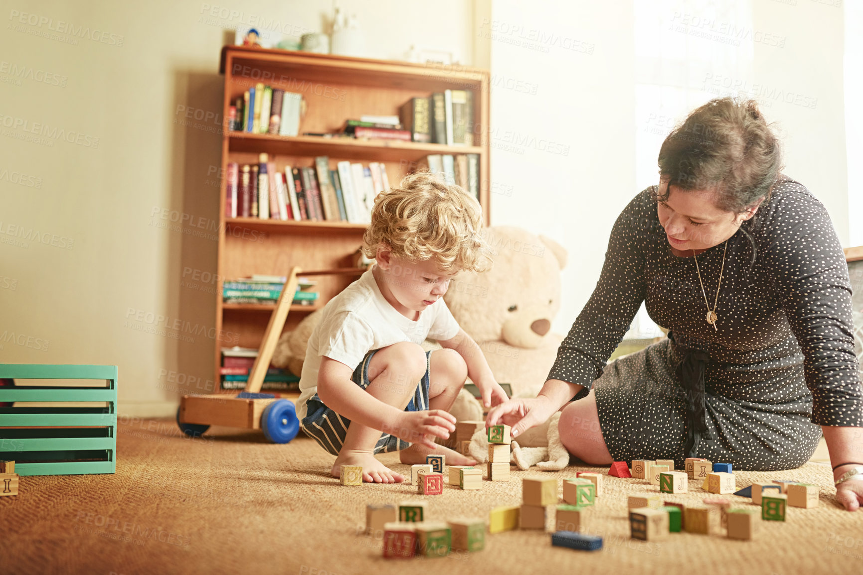 Buy stock photo Shot of a mother and her little son playing with wooden blocks at home