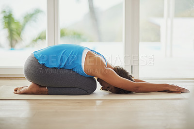 Buy stock photo Full length shot of a young woman practicing yoga at home