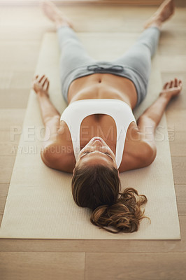 Buy stock photo High angle shot of a young woman practicing yoga at home