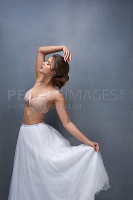 Buy stock photo Ballerina, dancing and woman with pose in studio for performance art, skill and practice of routine. Creative, elegance and dancer with skirt for ballet, talent and freedom on gray background