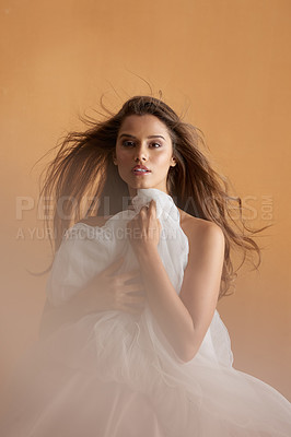 Buy stock photo Portrait of a beautiful young woman covering herself with a ballet skirt in studio