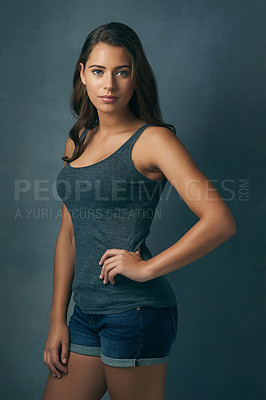 Buy stock photo Studio shot of a beautiful young woman posing against a blue background