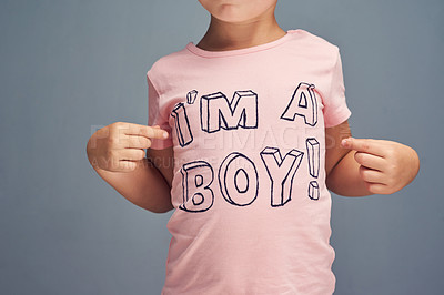 Buy stock photo Studio shot of a boy wearing a t shirt with “I’m a boy” printed on it against a gray background
